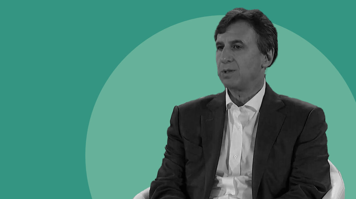 Black-and-white image of Apollo CEO Marc Rowan seated and speaking during an interview-style discussion, set against a soft circular graphic background. The visual reflects leadership perspective on capital allocation, private markets, and the role of long-term asset management in the financial system.