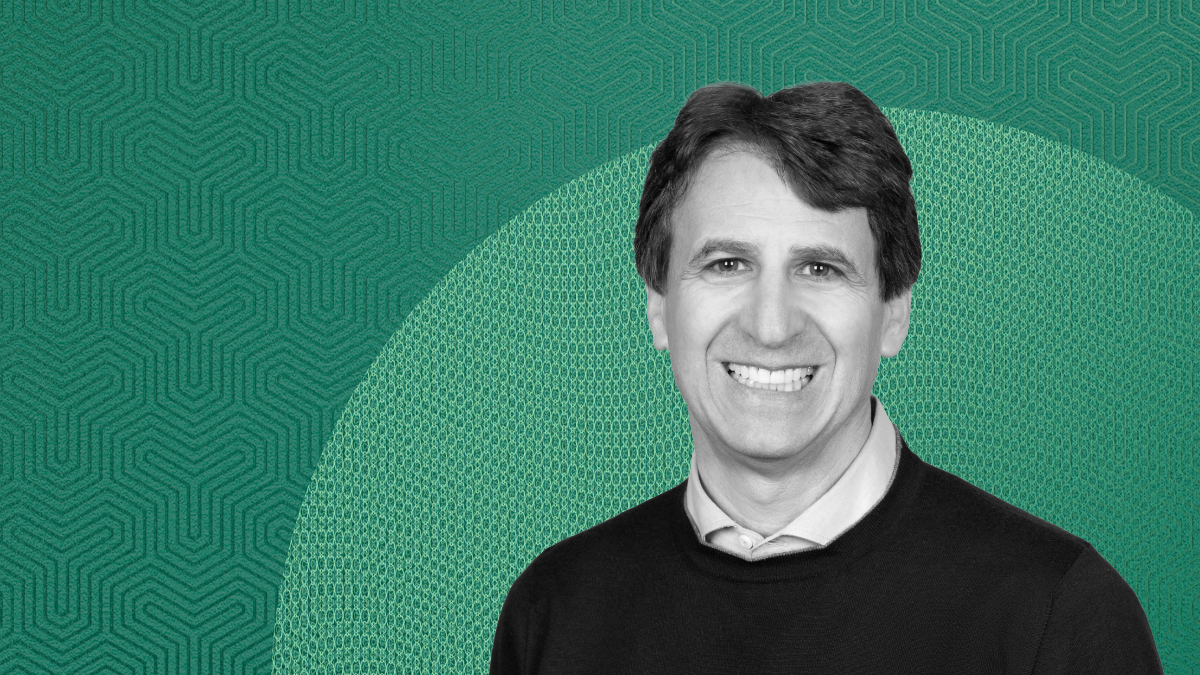 Black-and-white portrait of Marc Rowan, smiling in front of a teal geometric background, featured in a discussion on credit’s role in GDP growth.